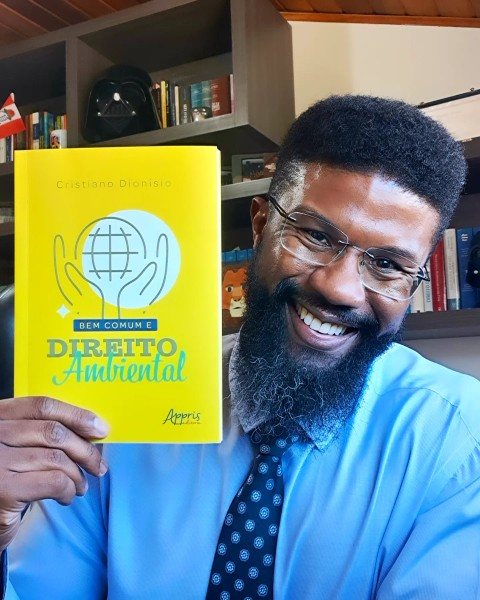 Cristiano Dionísio segurando exemplar do livro Bem Comum e Direito Ambiental